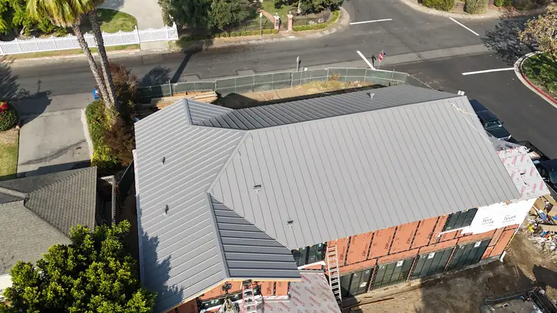 Gray standing seam metal roof with hips and valleys, seen from above