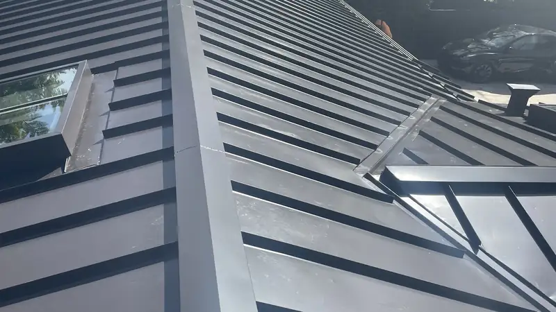 Standing seam metal roof ridge cap closing off the top of the panels