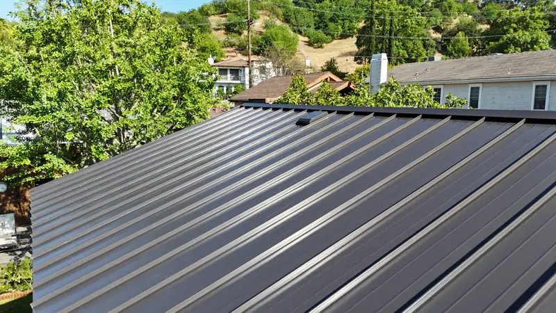 Close view of dark standing seam metal roof panels and their raised seams